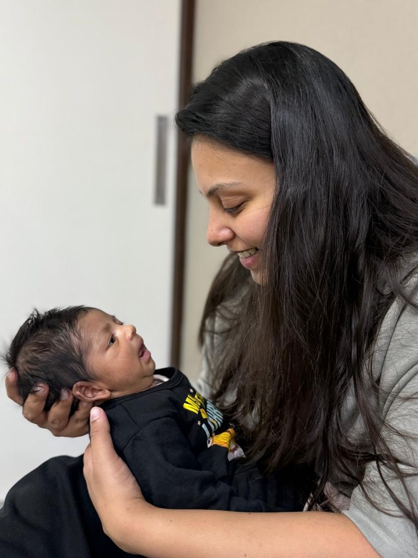 Rivaay looking up at a family member holding him, smiling