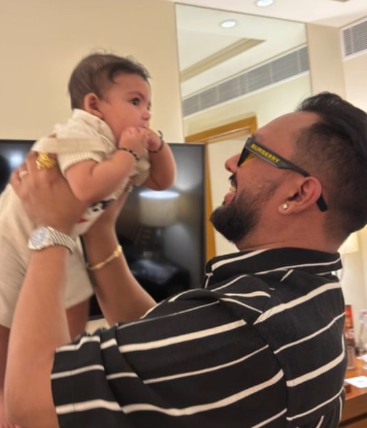 Dad lifting Rivaay up in the air, both smiling